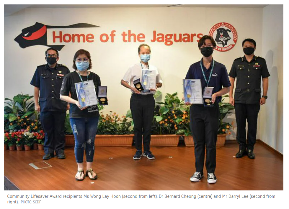 Darryl Lee with school staff after receiving an SCDF award for helping to save a man’s life.